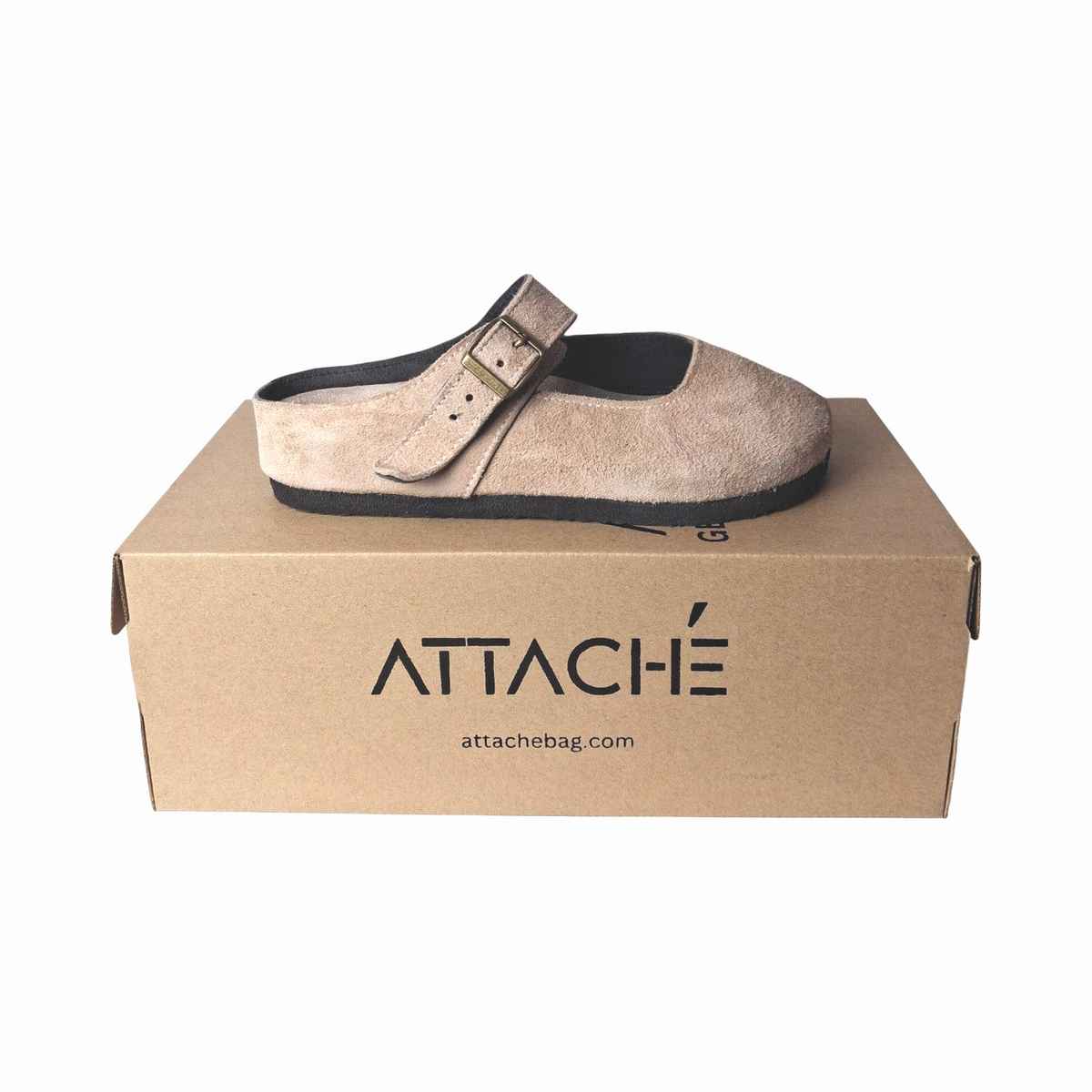 Attache Bags nude suede leather Merry Jane clog with an adjustable strap resting on a branded cardboard shoebox